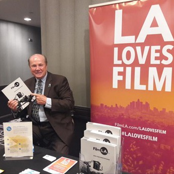 LA Loves Film table and sign with person holding flyers