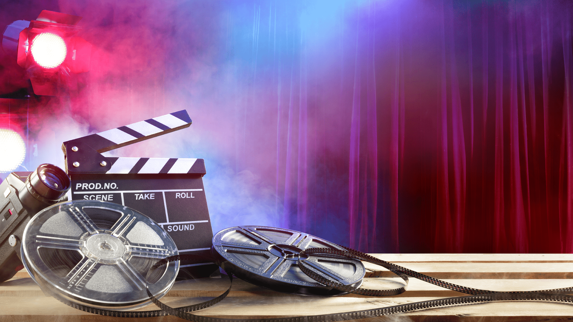 Film reel and clapboard in front of curtain